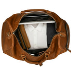 Khal Gold Ambassador weekender seen from above, packed with a folded white shirt, charcoal knitwear, a leather wash bag and a laptop