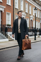 Man carrying the Khal Gold Gresham tan leather briefcase on a London street