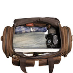 Interior of the Khal Gold Windsor leather holdall packed with folded clothes, a camera and a laptop in the main compartment
